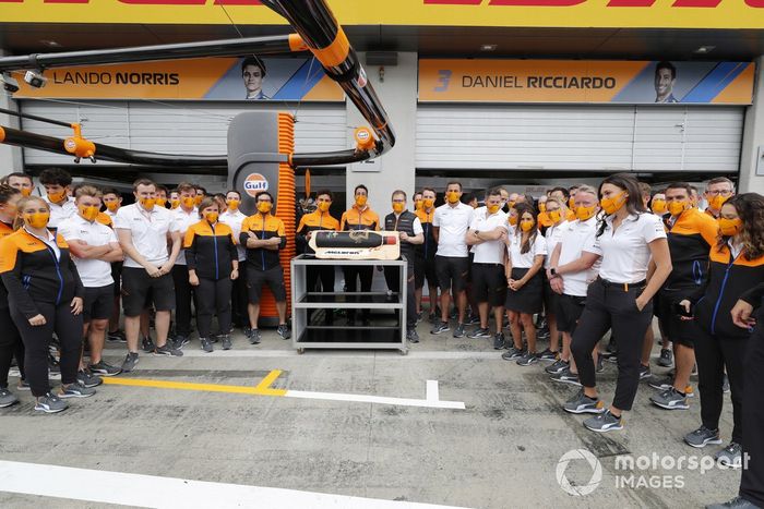 Lando Norris y miembros del equipo McLaren, con una tarta de cumpleaños de Daniel Ricciardo