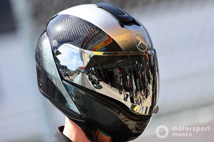 El coche de Lewis Hamilton, Mercedes W12, reflejado en el casco de un mecánico