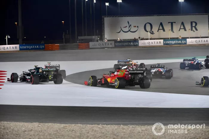 Sergio Pérez, Red Bull Racing RB16B, y Sebastian Vettel, Aston Martin AMR21, se van por fuera por delante de Charles Leclerc, Ferrari SF21