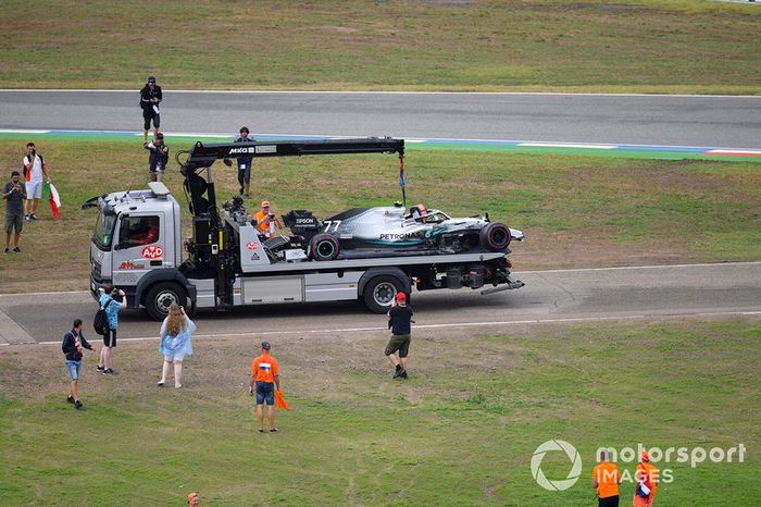 Los aficionados invaden el circuito después de la carrera mientras los oficiales retiran el coche de Valtteri Bottas, Mercedes AMG W10