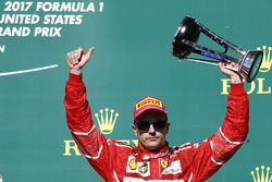 Third place Kimi Raikkonen, Ferrari, lifts his trophy