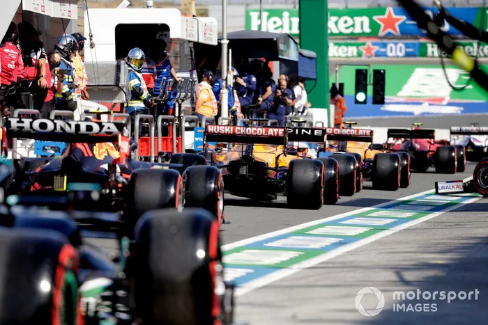 Daniel Ricciardo, McLaren MCL35M, y Sergio Perez, Red Bull Racing RB16B, en la cola del pit lane