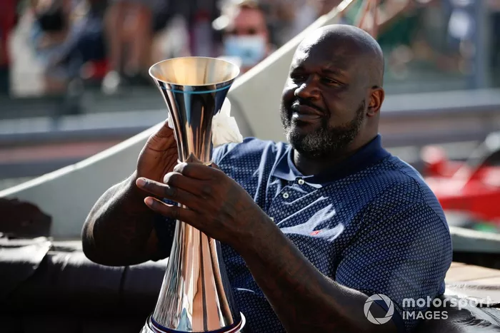La ex estrella del baloncesto Shaquille O'Neal llega a la ceremonia del podio con el trofeo