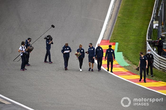 Pierre Gasly, AlphaTauri camina por el circuito llevando unas flores para Anthoine Hubert