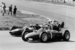 Phil Hill, Ferrari Dino 156, takes a wide line through Tarzan Corner while Trevor Taylor, Lotus 24-Climax, Ricardo Rodriguez, Ferrari Dino 156, and Jack Brabham, Lotus 24-Climax, are on the inside