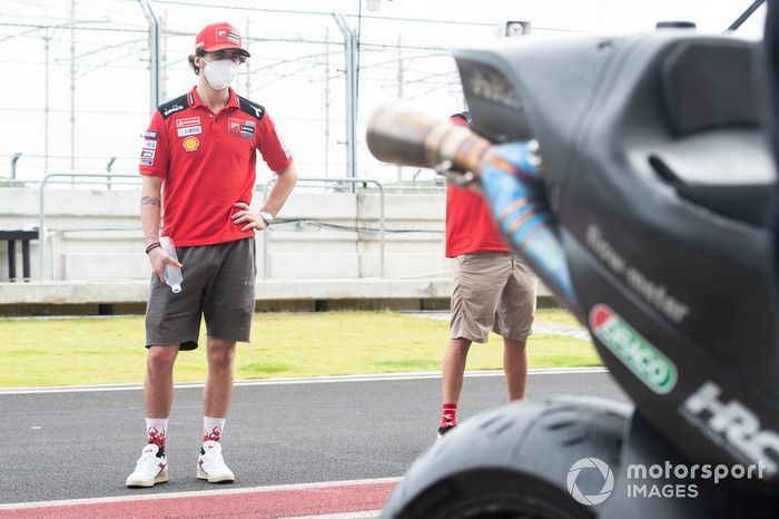 Francesco Bagnaia, Ducati Team, observando la moto del LCR Honda Team
