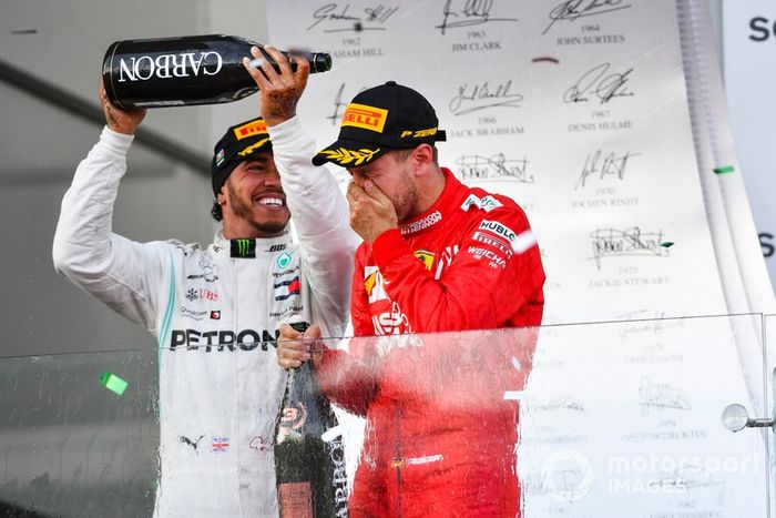 Lewis Hamilton, Mercedes AMG F1, secondo, versa champagne su Sebastian Vettel, Ferrari, terzo, sul podio