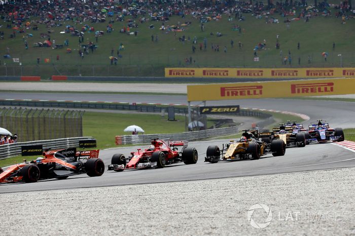 Fernando Alonso, McLaren MCL32 y Sebastian Vettel, Ferrari SF70H al inicio