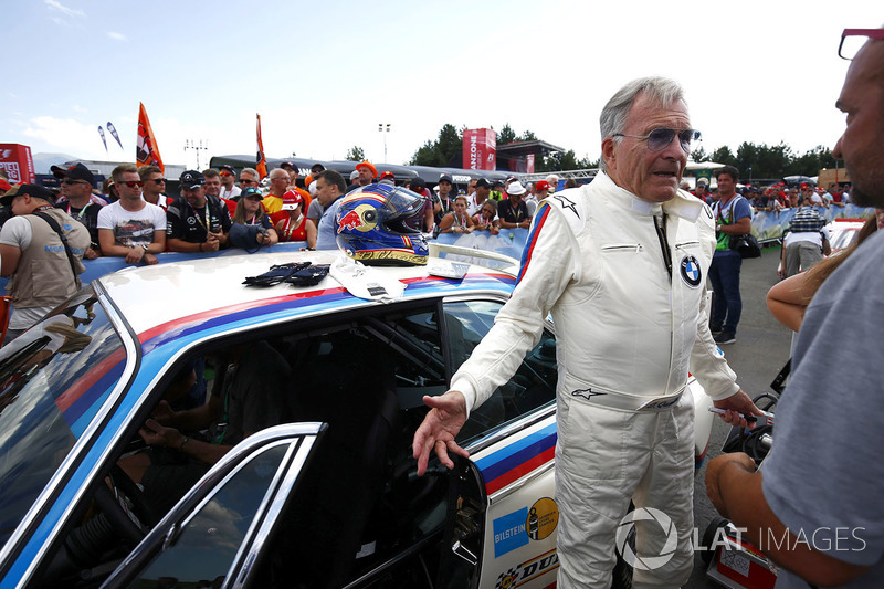 El piloto de BMW, Dieter Quester, habla con fans junto a su BMW CSL