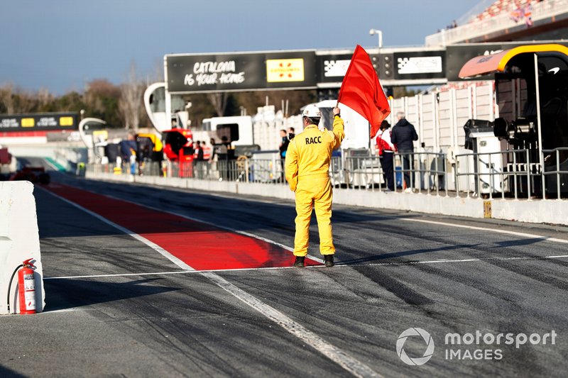 Marshal waves the red flag in pit lane