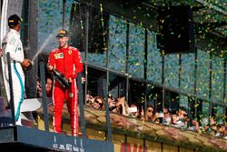 Lewis Hamilton, Mercedes AMG F1, 2nd position, and Sebastian Vettel, Ferrari, 1st position, celebrate with Champagne on the podium