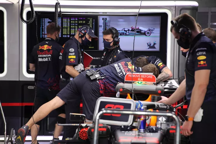Miembros del equipo Red Bull Racing trabajando en el alerón trasero