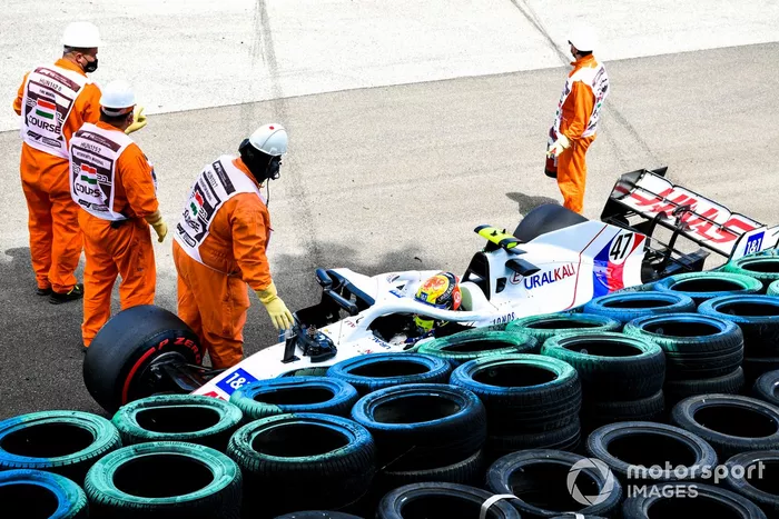 Los oficiales de pista asisten a Mick Schumacher, Haas VF-21, tras su accidente en la FP3