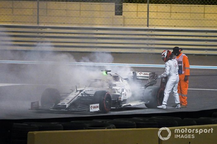 Kimi Raikkonen, Alfa Romeo Racing C39, ayuda a un oficial de pista a apagar el incendio de su monoplaza