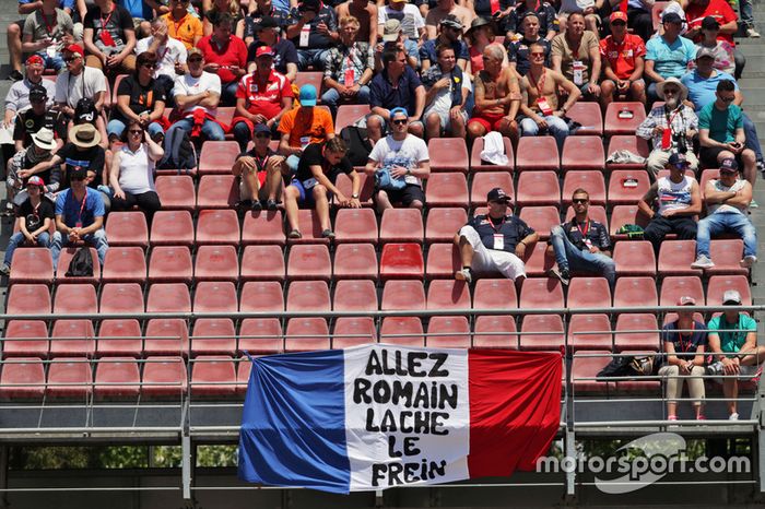 Romain Grosjean, banner de Haas F1 Team con fans en la tribuna
