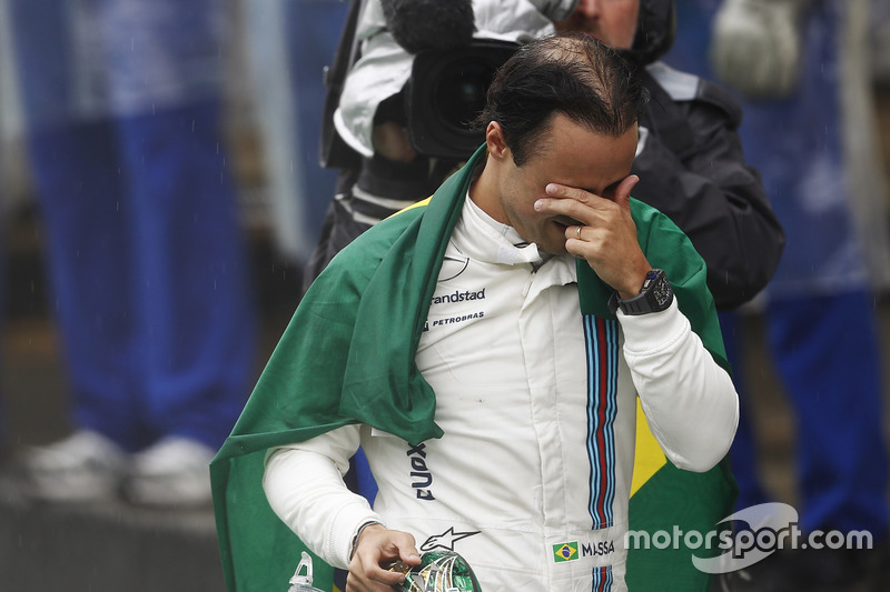 Felipe Massa, Williams, carries a Brazilian flag as he walks back to his garage in tears after crash