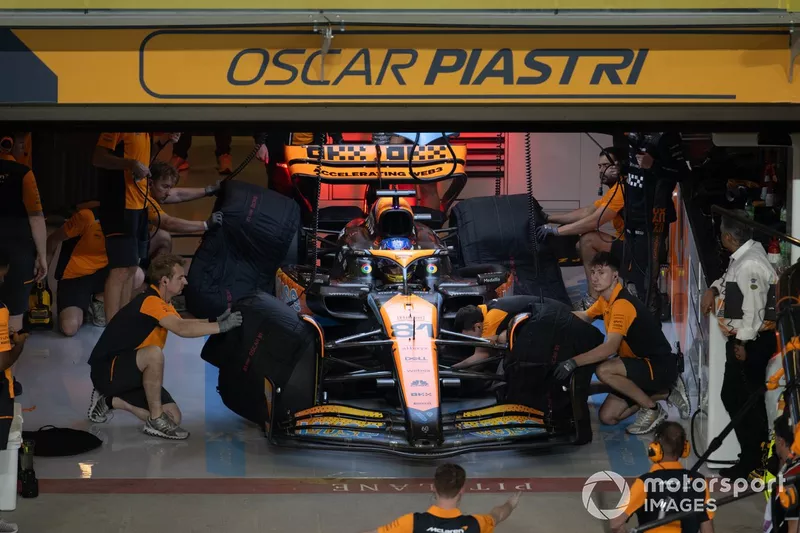 Meccanici in garage con Oscar Piastri, McLaren MCL60