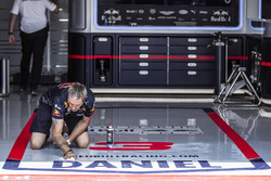 Red Bull Racing mechanic cleans the garage floor