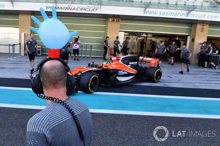 Lando Norris, McLaren MCL32 y un mecánico de McLaren  con un guante sobre sus cascos