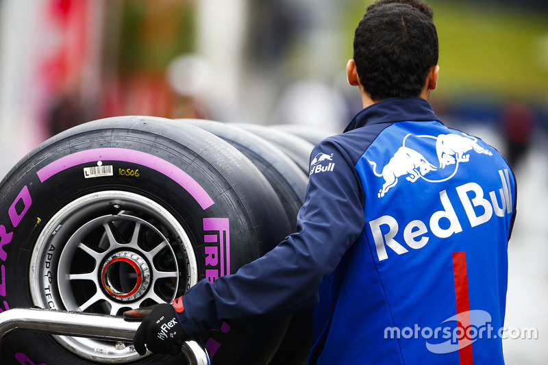 Un membro del team Toro Rosso attraversa il paddock con degli pneumatici Pirelli