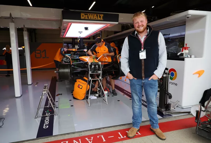 Kaleb Cooper pose pour une photo à l'extérieur du garage McLaren 