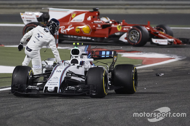 Sebastian Vettel, Ferrari SF70H, passes Lance Stroll, Williams FW40, as he climbs out of his damaged car