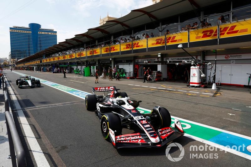 Oliver Bearman, Haas VF-24, sale del garaje por delante de Lewis Hamilton, Mercedes F1 W15