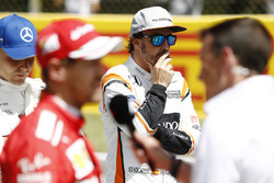Fernando Alonso, McLaren, aux côtés de Valtteri Bottas, Mercedes AMG F1, pendant que Sebastian Vettel, Ferrari, est interviewé