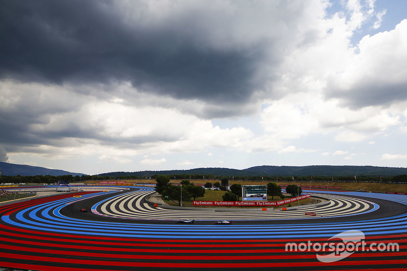 Kimi Raikkonen, Ferrari SF71H, leads Valtteri Bottas, Mercedes AMG F1 W09, and Kevin Magnussen, Haas F1 Team VF-18, under a cloudy sky