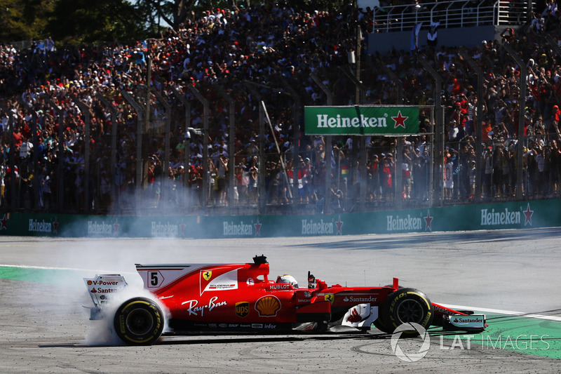 Sebastian Vettel, Ferrari SF70H, performs doughnuts as he returns to the pits after winning the race