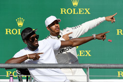 Race winner Lewis Hamilton, Mercedes AMG F1 celebrates on the podium with Usain Bolt