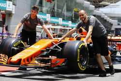 Les mécaniciens McLaren bougent la voiture de Fernando Alonso, McLaren MCL32