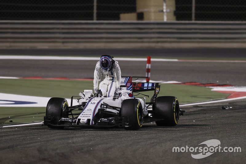 Lance Stroll, Williams FW40, climbs out of his damaged car after a collision with Carlos Sainz Jr., Scuderia Toro Rosso