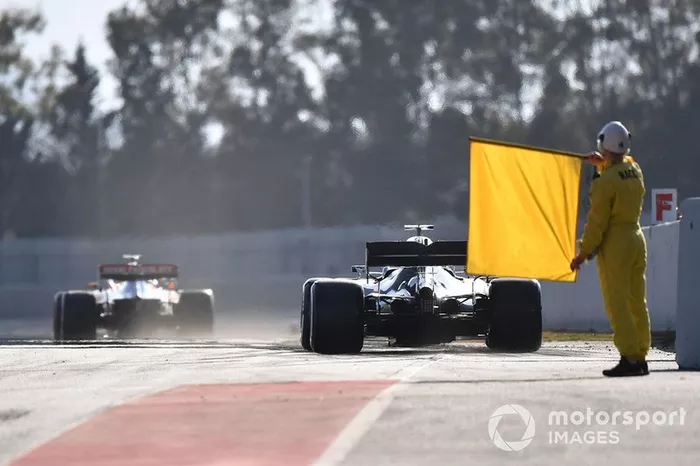 Comisarios con la bandera amarilla en el pitlane