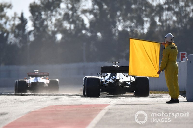 Commissario con una bandiera gialla in fondo alla pit lane