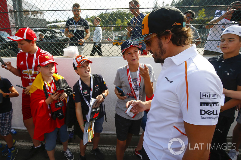 Fernando Alonso, McLaren, signs autographs for young fans