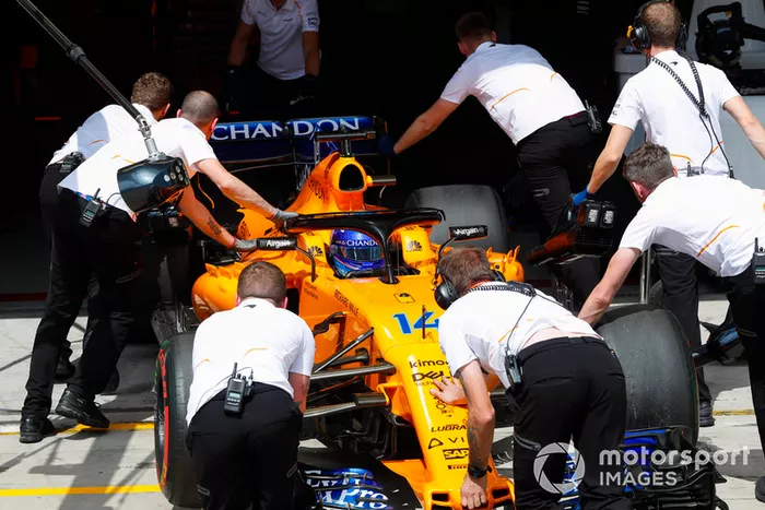 Los mecánicos regresan a Fernando Alonso, McLaren MCL33, al garaje.