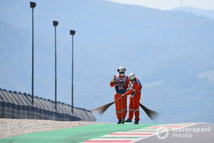 Los oficiales de pista barren el circuito