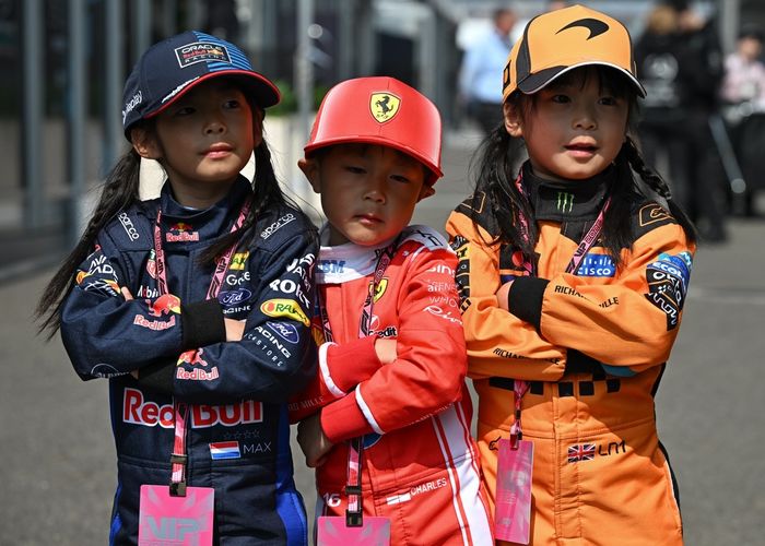 Three local children dressed in Red Bull Racing, Ferrari and McLaren driver apparel.