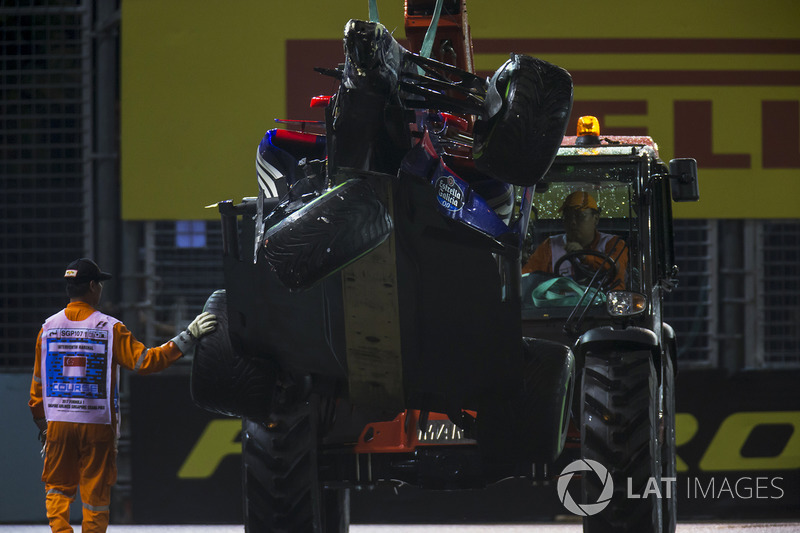 Marshals supervise a crane removing the wrecked Daniil Kvyat Scuderia Toro Rosso STR12