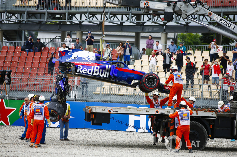 Marshals remove the damaged car of Brendon Hartley, Toro Rosso STR13, from the circuit as the gearbox hangs off the back