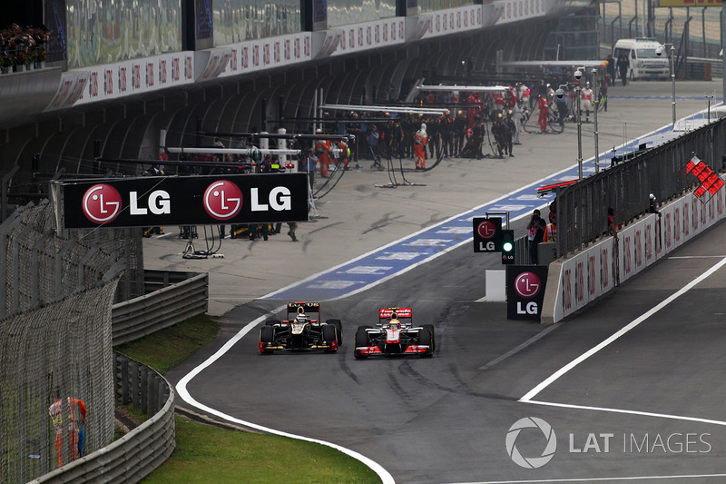 Kimi Raikkonen, Lotus E20 and Lewis Hamilton, McLaren MP4-27 battle in pit lane