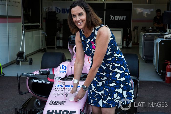Lee McKenzie, presentadora de canal 4 F1 pone una pegatina de la Asociación de atención de cáncer de mama en el Force India F1