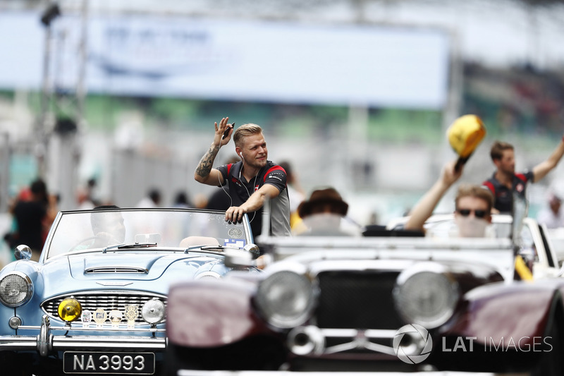 Kevin Magnussen, Haas F1 Team, waves to fans from an Austin Healey on the drivers parade