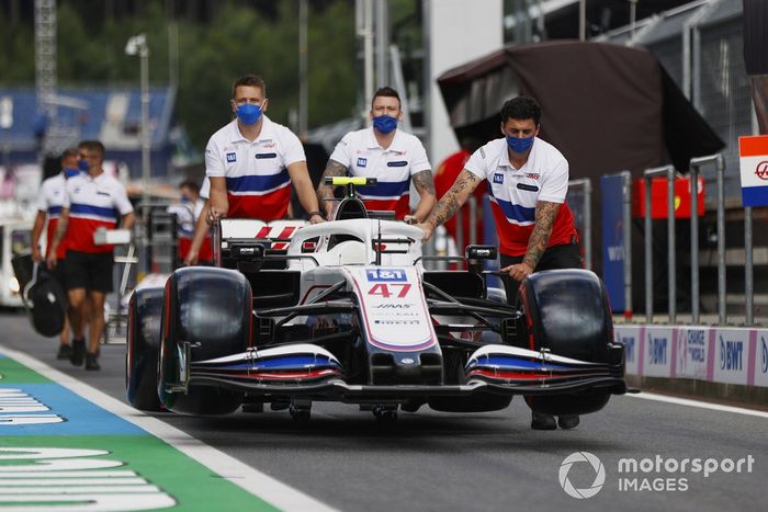 Los mecánicos de Haas F1 empujan el coche de Mick Schumacher, Haas VF-21, por el pitlane