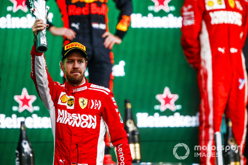 Sebastian Vettel, Ferrari, 2nd position, holds up his trophy on the podium