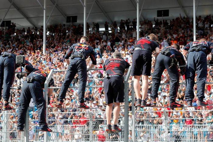 Los miembros del equipo de Red Bull Racing se suben a la valla al final de la carrera para animar a Max Verstappen, Red Bull Racing, 1ª posición, sobre la línea de meta