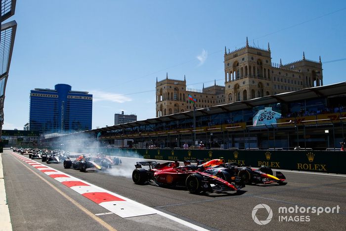 Arrancada Sergio Pérez, Red Bull Racing RB18, adelanta a Charles Leclerc, Ferrari F1-75 por el liderato en la salida. Max Verstappen, Red Bull Racing RB18 y Carlos Sainz, Ferrari F1-75 en la primera curva