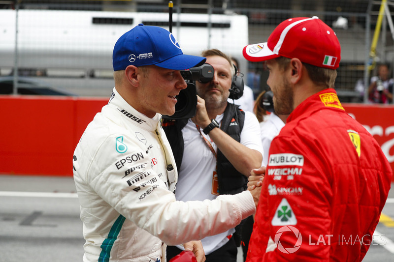 Il poleman Valtteri Bottas, Mercedes AMG F1, riceve le congratulazioni del terzo qualificato Sebastian Vettel, Ferrari