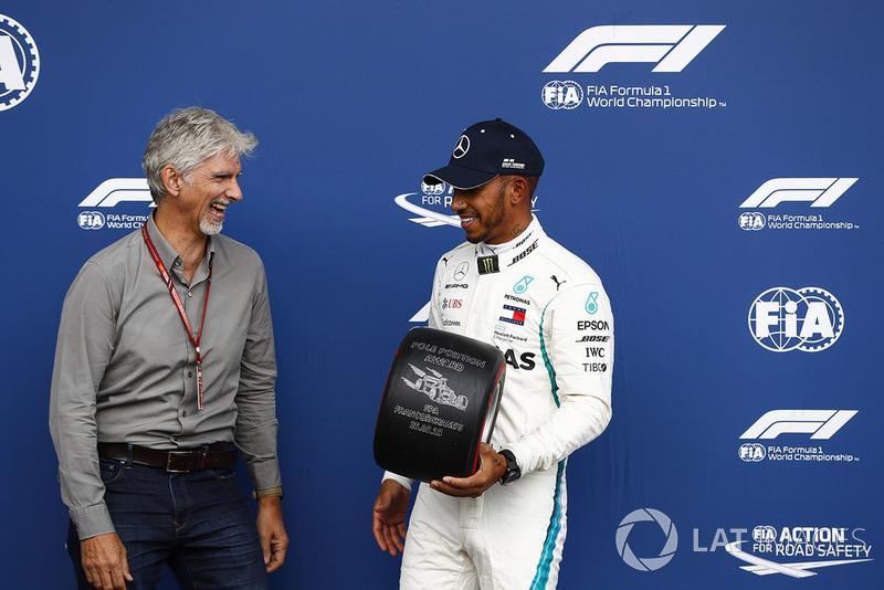 Damon Hill remet un trophée Pirelli à Lewis Hamilton après sa pole position